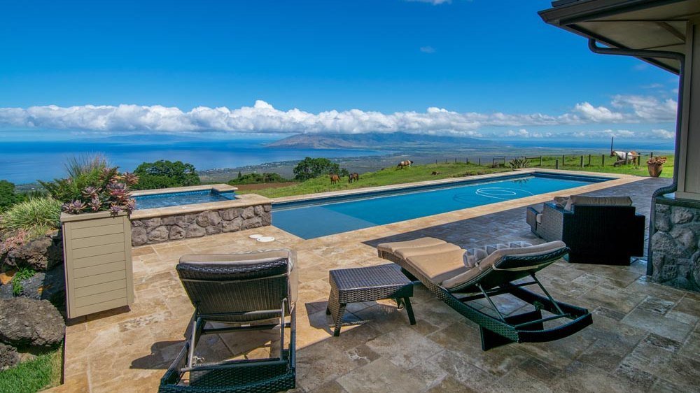 The pool and spa terrace at the edge of the estate, framed by ocean and sky