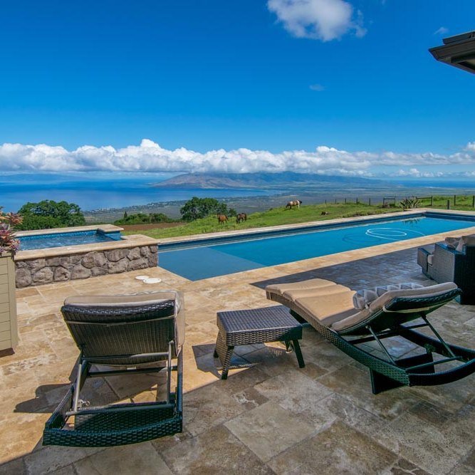 Pool and spa terrace with loungers overlooking the Pacific
