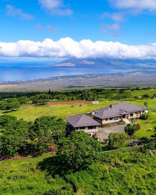 Aerial view of the estate set in green Upcountry pasture high above the Maui coastline and ocean